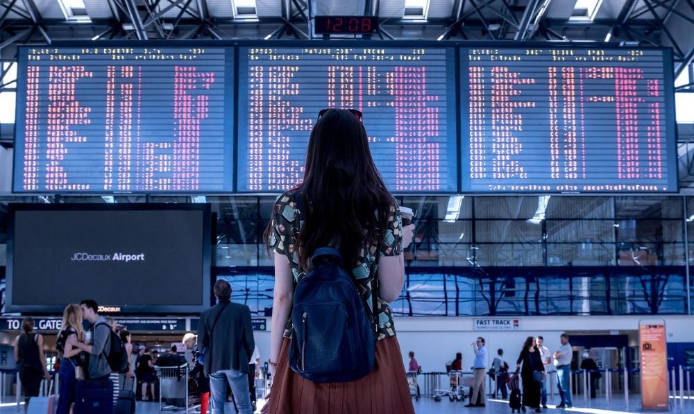Devojka koja gleda u red letova Slika kašnjenja aviona na aerodromu
